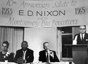 E.D. Nixon, segundo de la izq., organizador principal del boicot de buses en Montgomery, en acto en su homenaje en Nueva York en el décimo aniversario del boicot, diciembre de 1965. A su lado están Farrell Dobbs, secretario nacional del PST, y Arlette Nixon, activista del boicot y esposa de Nixon. En el podio está Clifton DeBerry, candidato del PST para presidente en 1964.