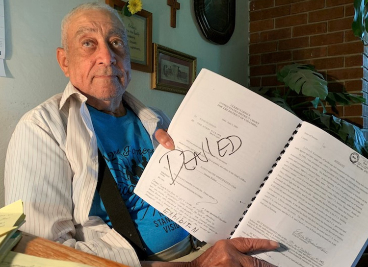 Bernard Bates, leader of fight by Black farmers to keep their land, shows documents from his legal battles. His dignity, courage and fighting spirit were inspiring to all who knew him.