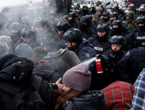 Policías canadienses atacan a camioneros y otros manifestantes en Ottawa el 19 de feb. El gobierno de Justin Trudeau usó Ley de Emergencias para socavar derechos, romper las protestas.