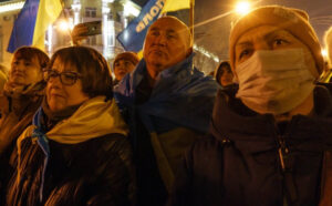 Hundreds protest Moscow’s assault on Ukraine’s sovereignty Feb. 22 in Mariupol, a city in the mostly Russian-speaking region of eastern Ukraine. Below, a sole Moscow protester, one of many in Russian cities the same day. Most were arrested. Sign says, "No war against Ukraine! This shouldn’t happen!"