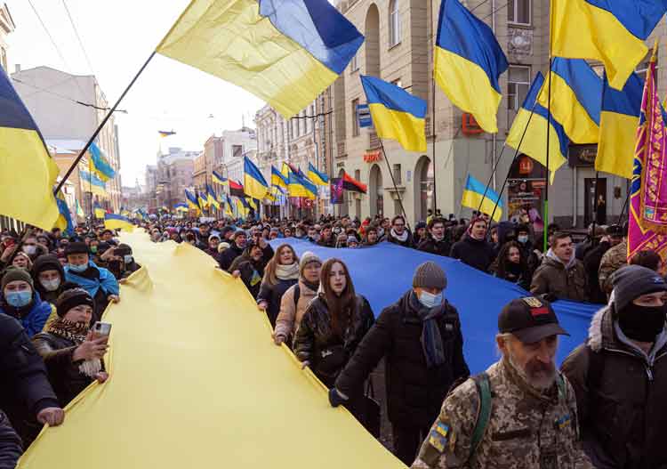 Over 5,000 protesters carry Ukrainian national colors in Kharkiv, Ukraine’s second-largest city, Feb. 5. Behind a banner saying, “Kharkiv is Ukraine,” they demanded an end to Russian threat of aggression only 25 miles from border where tens of thousands of Russian troops with tanks are deployed.