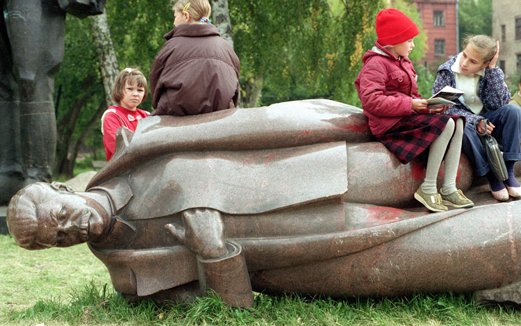 Children sit on toppled statue of Soviet dictator Joseph Stalin in Moscow, Sept. 11, 1991, after Soviet Union shattered. U.S. capitalist rulers thought this meant they won the Cold War, and that would bring global stability under their dominion. That has been proven utterly false.