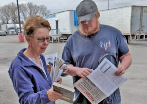 Alyson Kennedy, SWP candidate for Texas governor, shows truck driver Richard Swim Militant and book Teamster Rebellion at truck stop March 29. “Workers need fighting unions,” she said.