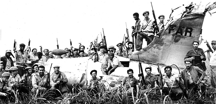 Celebrating defeat of Washington’s Bay of Pigs invasion by 1,500 U.S.-organized mercenaries, April 1961, Cuban militiamen pose with wreckage of downed U.S. plane in fake Cuban colors. Fidel Castro said U.S. imperialists couldn’t forgive the workers and peasants of Cuba for “making a socialist revolution right under their very nose.”