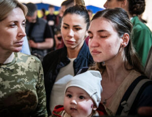 Anna Zaitseva con hijo en Zaporizhzhia tras evacuación de acería Azovstal en Mariúpol, 30 de abril. Su esposo se quedó para ayudar a combatientes que resisten intenso ataque por Moscú.