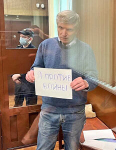 Alexei Gorinov, an opposition elected deputy in Moscow, on trial for “discrediting” the Russian military, holds a sign June 21 saying, ”I’m against the war.”