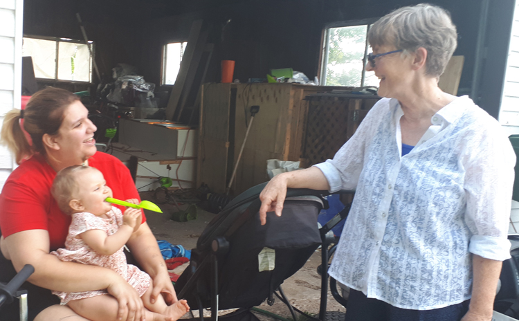 Katy LeRougetel, right, Communist League candidate in Quebec provincial election, speaks with Kiève Parisée June 21 in rural Princeville, Quebec. Parisée and her husband were laid off two days earlier.
