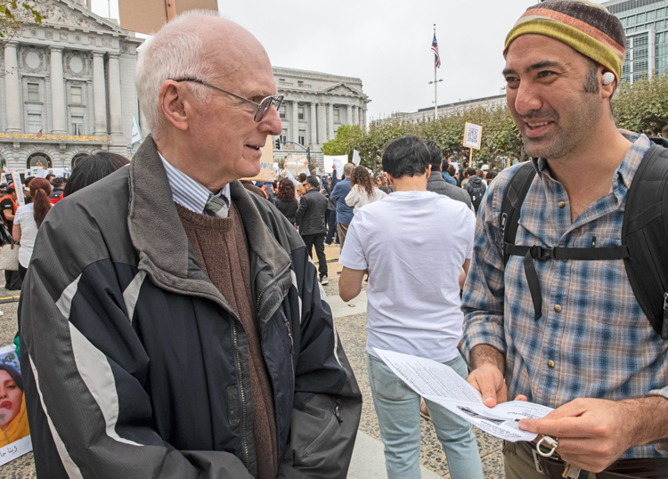 Joel Britton, left, Socialist Workers Party candidate for governor of California, discusses politics with protester while campaigning at Iran solidarity rally of 2,000 in San Francisco Oct. 9.