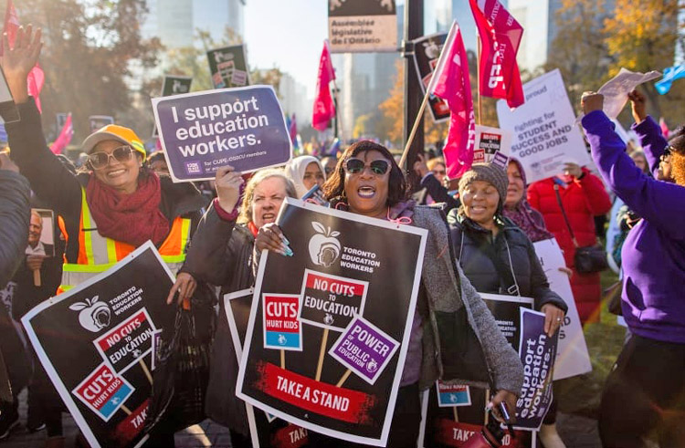 School workers and supporters rally in Toronto Nov. 4 after CUPE members walked off job, forcing Ontario government to back down, rescinding draconian anti-strike law. This set an example for unionists everywhere facing gov’t threats against use of union power to support workers’ interests.