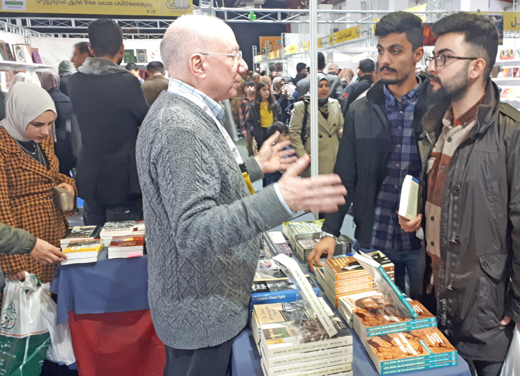 Pathfinder volunteer Jim White, center, at Sulaymaniyah book fair, Nov. 17-26. Developments in the region and world politics boosted interest in books on lessons of revolutionary struggles.