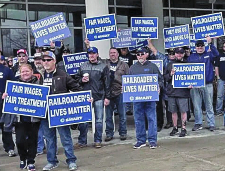 Rail workers picket Omaha meeting of Berkshire Hathaway, which owns BNSF railroad, April 30, part of hard-fought battle for livable schedules, paid sick days, control over work conditions.