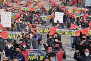 Hundreds of the 25,000 striking unionized truckers march in Uiwang, South Korea, Nov. 24, one of 16 nationwide rallies that day. South Korean government is trying to force them back to work. Signs demand a guaranteed minimum rate, safer working conditions.