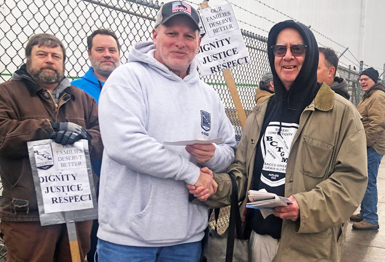 Mike Moore, center, president of BCTGM Local 100G, on strike against Ingredion in Cedar Rapids, Iowa, receives check on picket line for $1,521 from Dan Fein and Veronica Hopkins (taking picture) Dec. 29 from BCTGM Local 1 collection at Mondelez bakery in Chicago.