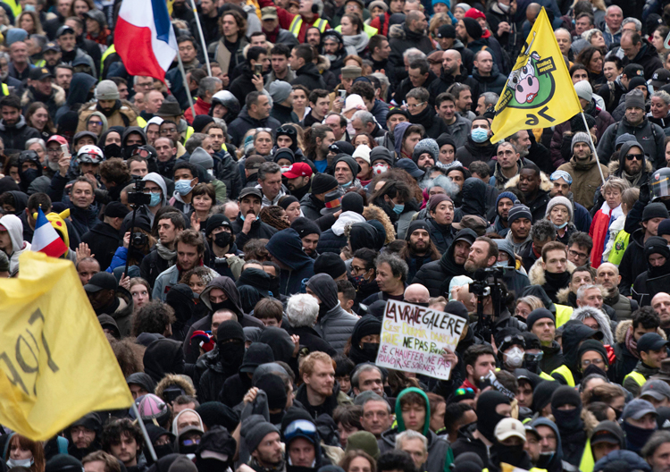 Thousands demonstrate in Paris Jan. 7 demanding higher wages to cover soaring prices and to protest President Emmanuel Macron’s plan to increase retirement age beyond 62 years.