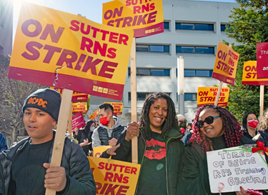 Striking nurses and supporters rally Jan. 1 outside a Sutter hospital in Oakland, California. They’re fighting for increased staffing, better working conditions, against hospital closures.