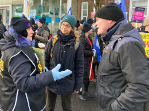 Maggie Heaton, left, Royal College of Nurses union representative for North West England, discusses strike for pay raise and improved working conditions Jan. 18 with rail workers Ólof Andra Proppé and Gary Boyle, who brought solidarity from Manchester Piccadilly Station.
