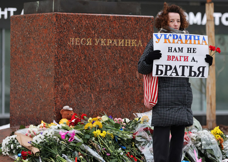 Woman holds sign, “Ukraine: not our enemies, but our brothers,” at monument to Ukrainian poet Lesya Ukrainka in Moscow Jan. 21. Bouquets, toys placed at sites in 50 cities protesting Moscow’s deadly Jan. 14 strike on Dnipro apartments show growing opposition to Putin’s war.