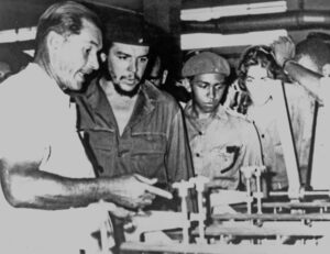 Che Guevara, in uniform, visits a factory as Cuba’s minister of industry in the early 1960s. Along with Fidel Castro, Che was part of Cuba’s Marxist leadership that led workers to take control of production to maximize meeting needs of working people, ensure safety on the job.