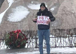 Iván Popov con cartel que dice, “¡No a la guerra!” en estatua de “Pedro el Grande” en San Petersburgo, Rusia, a un año de guerra de Moscú. Piquetes, “protestas de flores”, movimiento de cintas verdes mantienen visible oposición a régimen de Putin, solidaridad con pueblo ucraniano.