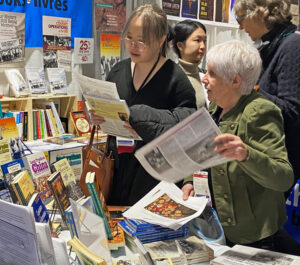 Beverly Bernardo, front right, from the Communist League in Canada, shows Militant, socialist literature to a participant at the March 16-19 Association for Asian Studies Conference in Boston. The conference attracted over 3,400 academics, students and librarians.