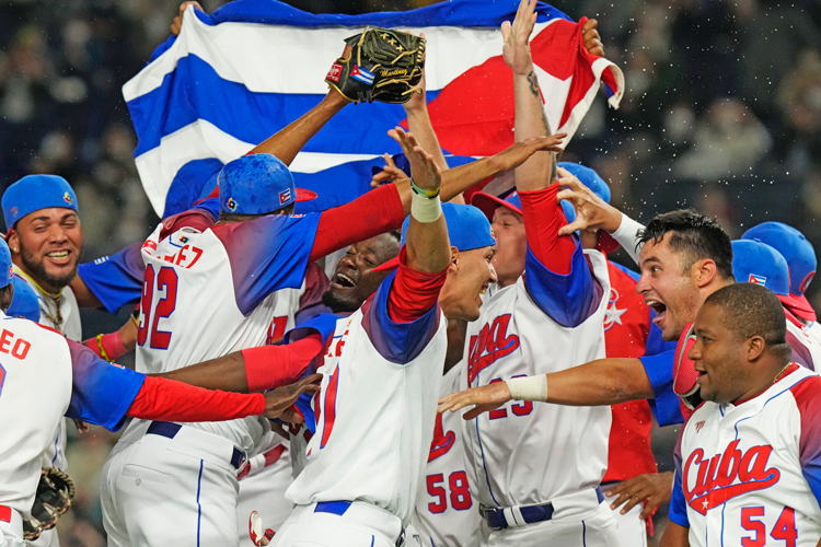 Cuban players celebrate win in World Baseball quarterfinal against Australia in Tokyo, March 15. Four days later, they played with dignity in Miami semifinal loss to U.S. team. Most fans backed the Cubans, but city officials turned blind eye as rightists tried to disrupt the game.