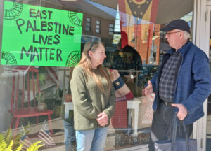 Tony Lane, del PST en Pittsburgh, extiende solidaridad a Joy Mascher en su floristería en East Palestine, 16 marzo. “Vidas de East Palestine importan”, dice cartel que hizo el hijo de Mascher.