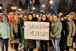 Mothers and wives of Russian soldiers hold sign March 11 that reads “580 Separate Howitzer Artillery Division” in video charging “our mobilized men are being sent like lambs to the slaughter.” Inset, Olga Tsukanova, a leader of Council of Soldiers’ Mothers and Wives, who has protested Moscow’s war policies and treatment of soldiers.