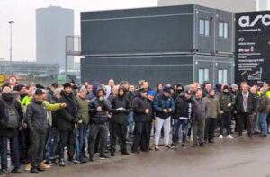 Sanitation workers on strike in Copenhagen, Denmark, set up mass picket outside gate at municipal recycling and power plant. They oppose government moves to expand work hours.