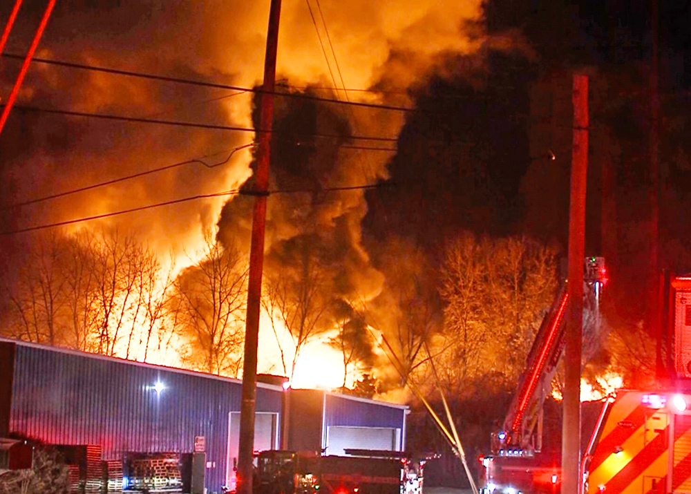 Fire blazes among damaged rail cars filled with toxic chemicals in East Palestine, Ohio, Feb. 4, day after derailment. Disaster was caused by rail bosses’ drive for profits over everything else.