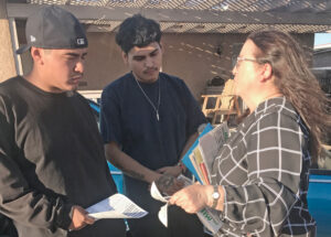 Laura Garza, SWP candidate for U.S. Senate from California, campaigning Oct. 22 in El Centro, Imperial County, talks to Jonathan Espinoza, left, seasonal worker at Spreckels Sugar plant, and Alfredo Fernández, who used to work in the fields. They got a copy of the Militant.