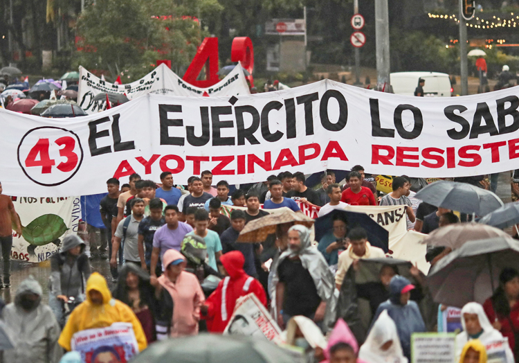 July 26 Mexico City march for justice for 43 disappeared Ayotzinapa students. Banner reads: “The army knows.” President López Obrador increasingly relies on “incorruptible” military.