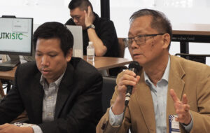 Xia Jiang, right, professor from China’s Huaqiao University, addresses Dec. 10 ISSCO workshop. Washington has repeatedly suspected Chinese scientists of “being disloyal to the U.S.,” he said, “some even accused of being spies.” Inset, Audience at opening conference session Dec. 9.