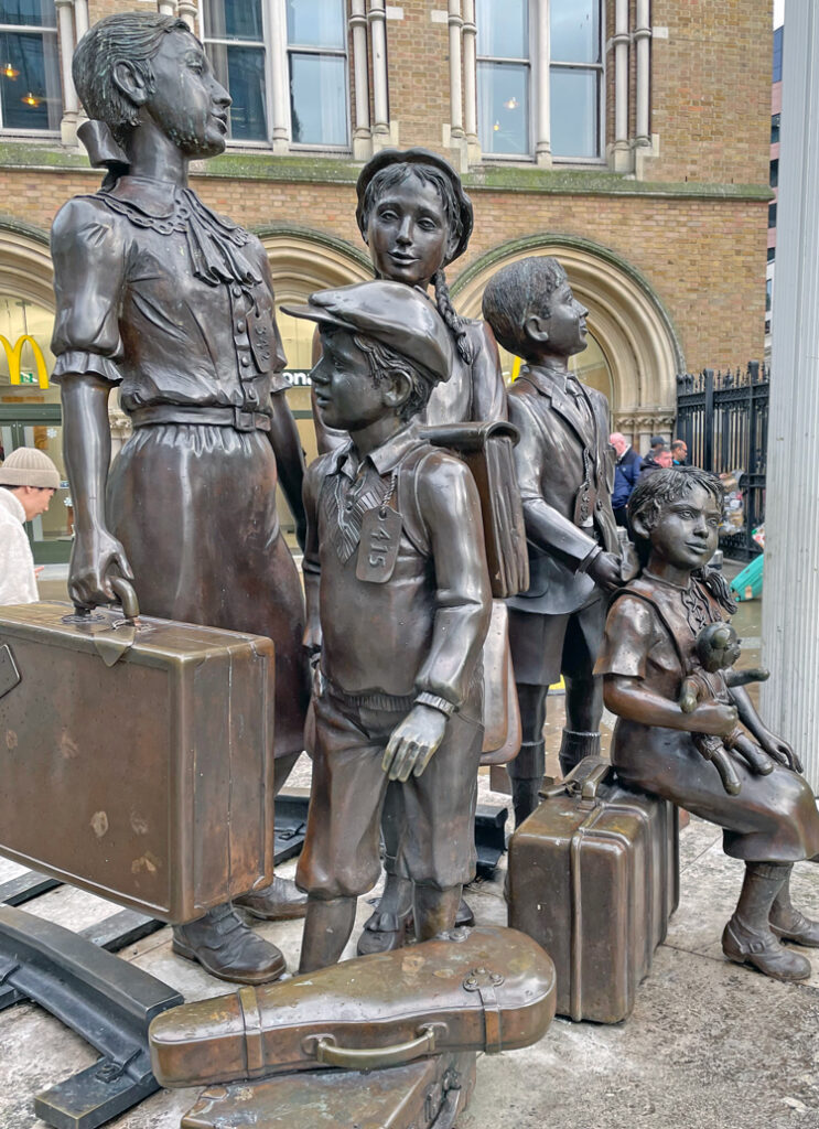 Statue outside London train station commemorates Kindertransport children. To escape Nazi terror in Europe, for 10 months U.K. rulers let in 10,000 mainly Jewish children, but barred their families. They closed the door on millions seeking refuge from the Holocaust.