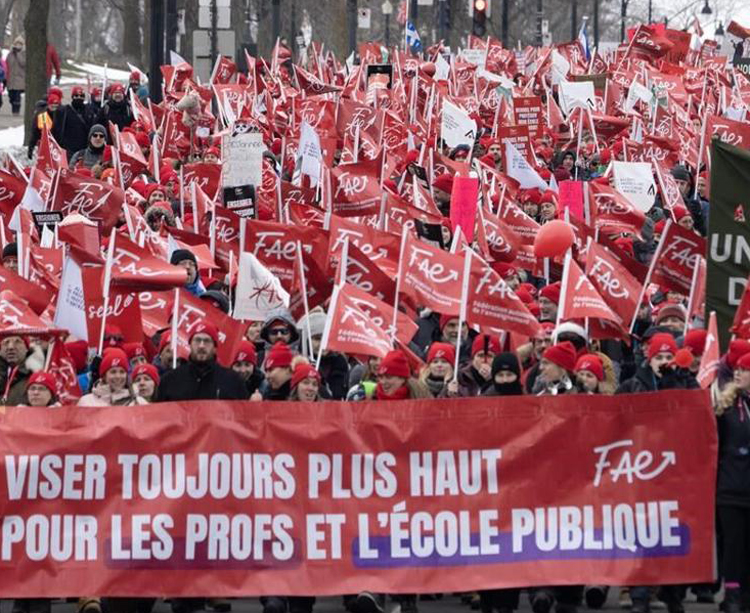 Striking teachers march in Montreal Dec. 12. Banner reads, “Aiming higher for teachers and public schools.” Almost 600,000 public sector workers have walked picket lines across Quebec, often at the same time, forcing the government to offer tentative settlements Dec. 28.