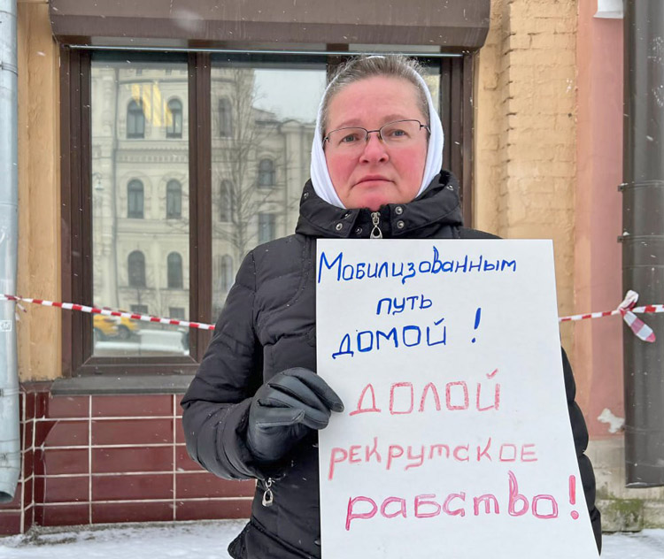 Wife of Russian soldier fighting in Ukraine protests outside government offices in Moscow Jan. 6. Her sign says, “Get the mobilized soldiers home! Down with conscription slavery!”