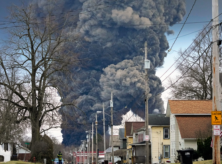 Columnas de humo en East Palestine, Ohio, feb. 6, 2023, después de que patrones ferroviarios deliberadamente prendieron fuego a sustancias tóxicas, tres días después de descarrilamiento.
