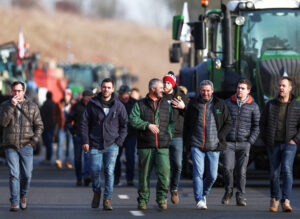 Farmers in Beauvais, France, walk on highway toward Paris Jan. 29. Across Europe farmers are protesting skyrocketing costs, choking “climate change” rules, cuts in pay for their produce.