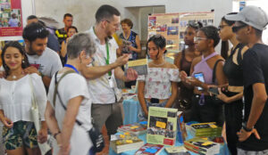 Philippe Tessier, center, from Communist League in Canada, shows books, discusses with young people in lively Pathfinder bookstall at Havana International Book Fair Feb. 17. 