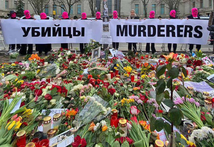Memorial at Russian Embassy in Berlin, Feb. 18. Banner by Pussy Riot members denounces Kremlin murderers. Two days earlier, Russian authorities announced that Alexei Navalny, prominent critic of Putin regime, war in Ukraine, died in Russian gulag prison. Inset, Marina Ovsyannikova, who was fired for protesting March 2022 on live Russian TV against Moscow’s invasion of Ukraine, holds sign at Berlin gathering quoting Navalny, “Don’t give up.”
