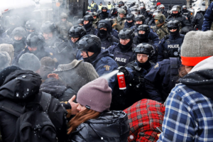 La police canadienne utilise du gaz poivré et fonce dans la foule de camionneurs et d’autres manifestants du Convoi de la liberté à Ottawa, le 19 février 2022, après que le gouvernement de Justin Trudeau a invoqué la tristement célèbre Loi sur les mesures d’urgence.