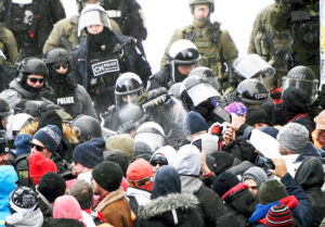 Canadian riot police use pepper spray against truckers, other protesters in Ottawa, Feb. 19, 2022. Despite Emer-gencies Act being recently ruled illegal by federal judge, Justin Trudeau government is pressing new attack on political rights, the Online Harms Act.