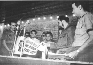 Havana, November 1961. Che Guevara, minister of industry, gives “Territory Free of Illiteracy” banner to workers at paint factory. “We’re not trying to set a world record,” he said. “We’re teaching people to read and write so you can learn other things, and combine study and work.”