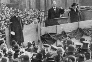 Revolutionary internationalist leaders Rosa Luxemburg, inset, speaking in Stuttgart, Germany, in 1907 and Karl Liebknecht, speaking in Berlin in 1918. The two revolutionaries, jailed by the German government for opposing imperialist war, hailed victory of the Bolshevik Revolution.