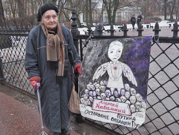 Artist Elena Osipova protests Feb. 24 in St. Petersburg, Russia, with a painting in memory of Alexei Navalny, outspoken critic of Putin and his Ukraine invasion, killed Feb. 16 in Arctic prison. Under Navalny’s image and name it reads “Stop Putin’s [special military] operations.” 