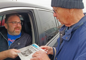 Uber drive Paul Brown, left, gets Militant subscription from SWP member Dan Fein April 1 at O’Hare airport. Brown liked idea Fruit raises of building a labor party based on the unions.