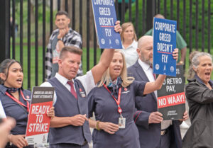 American Airlines workers, members of Association of Professional Flight Attendants, with no raise in five years, rally in Washington, D.C., elsewhere, May 9 demanding right to strike.
