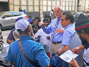Dennis Richter, center, Socialist Workers Party candidate for vice president, campaigns in New York among delivery workers, many from West African countries, May 24. He said workers in the U.S. and Africa have common interests in the fight against capitalist rule.