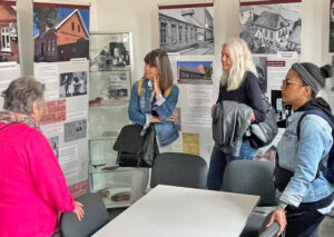 Almut Holler, left, and Petra Drueke, second from right, leaders of Ecumenical Working Group, show visitors educational center housed in former Jewish school in Norden, Germany, July 1.