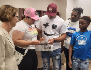 Ysmenia Silva Rosales and Angel Montezuma Peña sign up to endorse SWP campaign Aug. 10. At left, Alyson Kennedy, SWP candidate for U.S. Senate. Keashia Davis, with grandson at right.