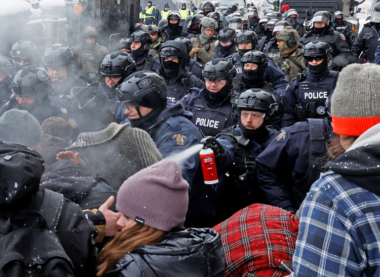 Police pepper spray protesting truckers in Freedom Convoy, Ottawa, Feb. 19, 2022. Despite court ruling use of Emergencies Acts was illegal, assault on convoy spokespeople continues.